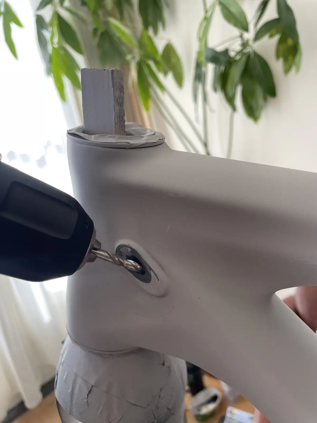 Drill in hand, mid-cut on the frame