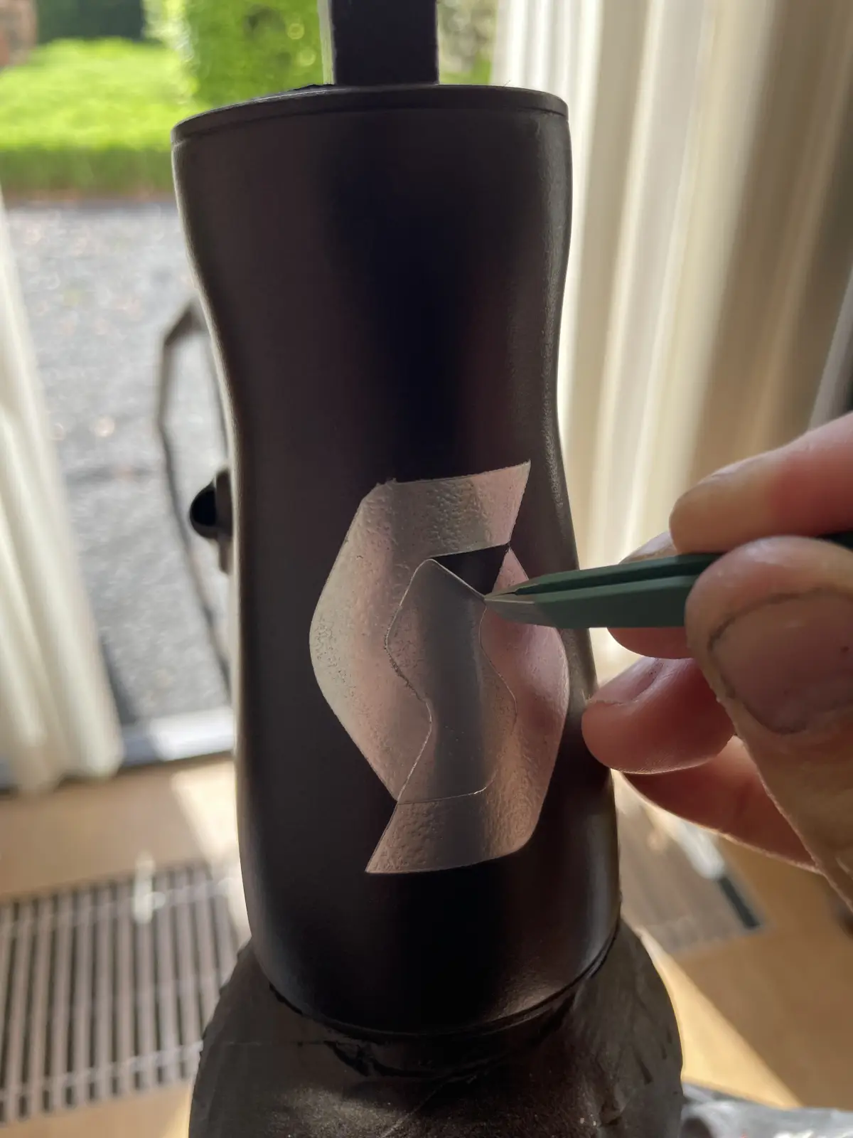 Lifting the S-icon stencil off the head tube with tweezers