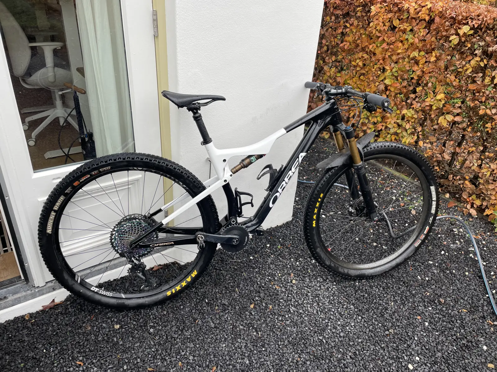 Orbea resprayed in black and white, full bike against a wall